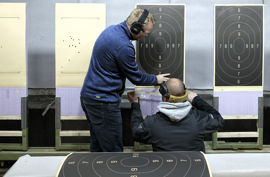 Twee leden van de schietsportvereniging SV Beilen hangen nieuwe schietschijven op binnen de eigen 25 meter schietbaan